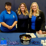 Transmarine employees standing behind a booth at the California Maritime Academy’s 2024 Fall Career Fair